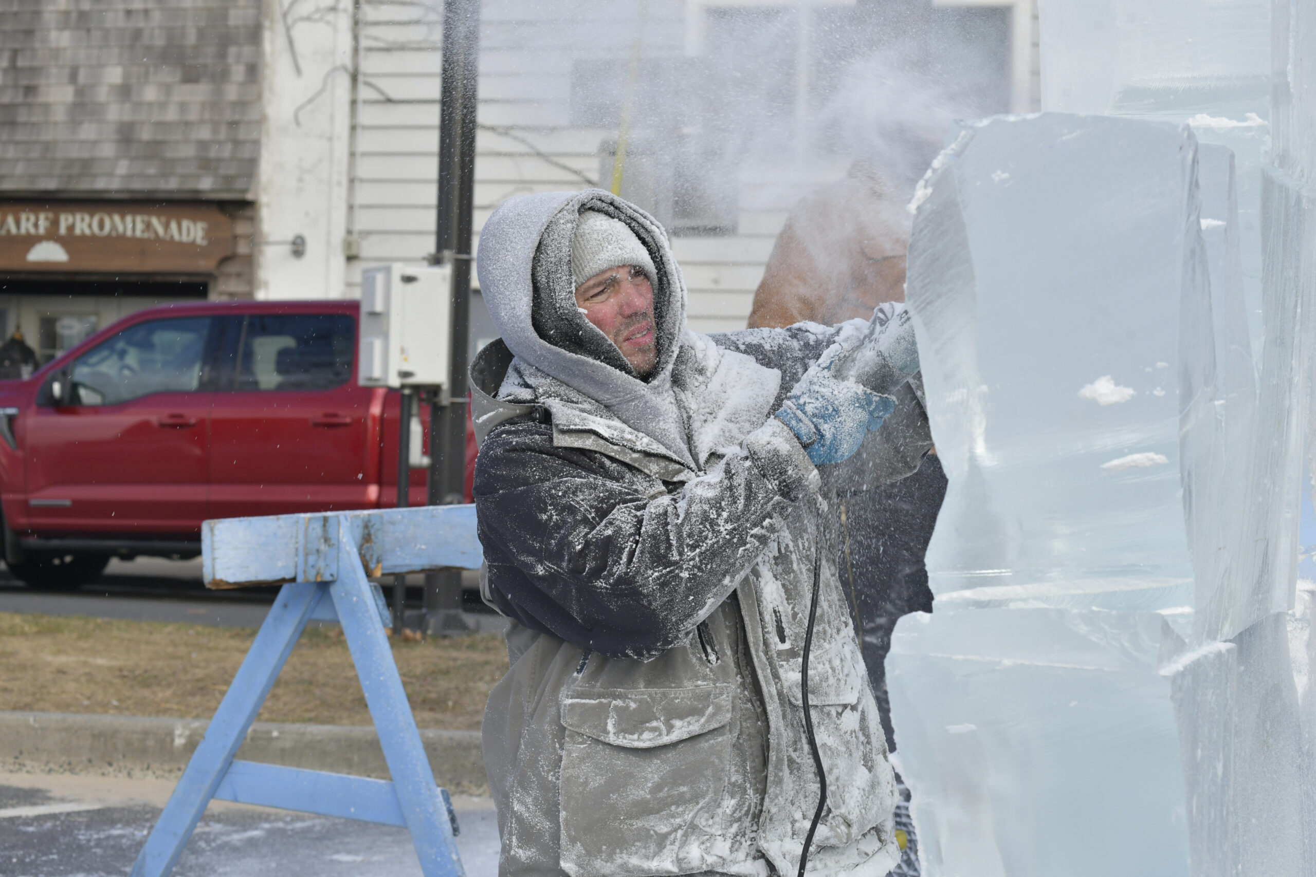 Ice carver Rich Daly works on a sculpture of Neptune on Long Wharf on Saturday during HarborFrost.   DANA SHAW