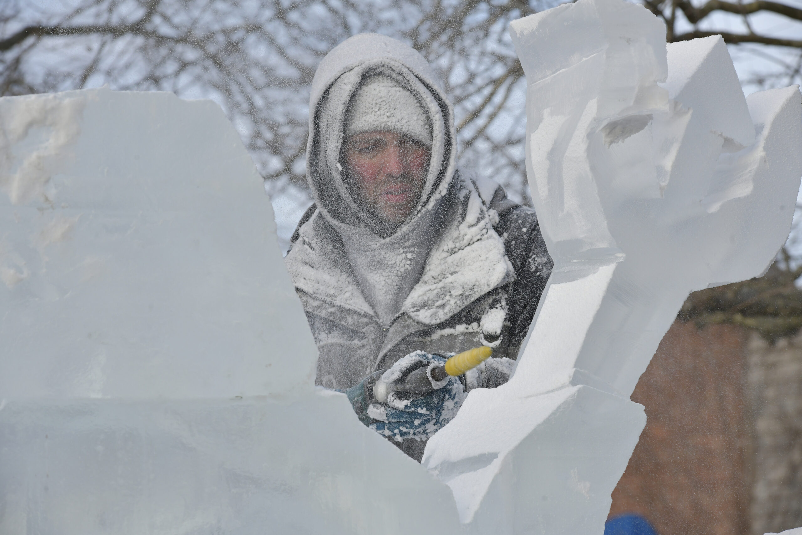 Ice carver Rich Daly works on a sculpture of Neptune on Long Wharf on Saturday during HarborFrost.   DANA SHAW