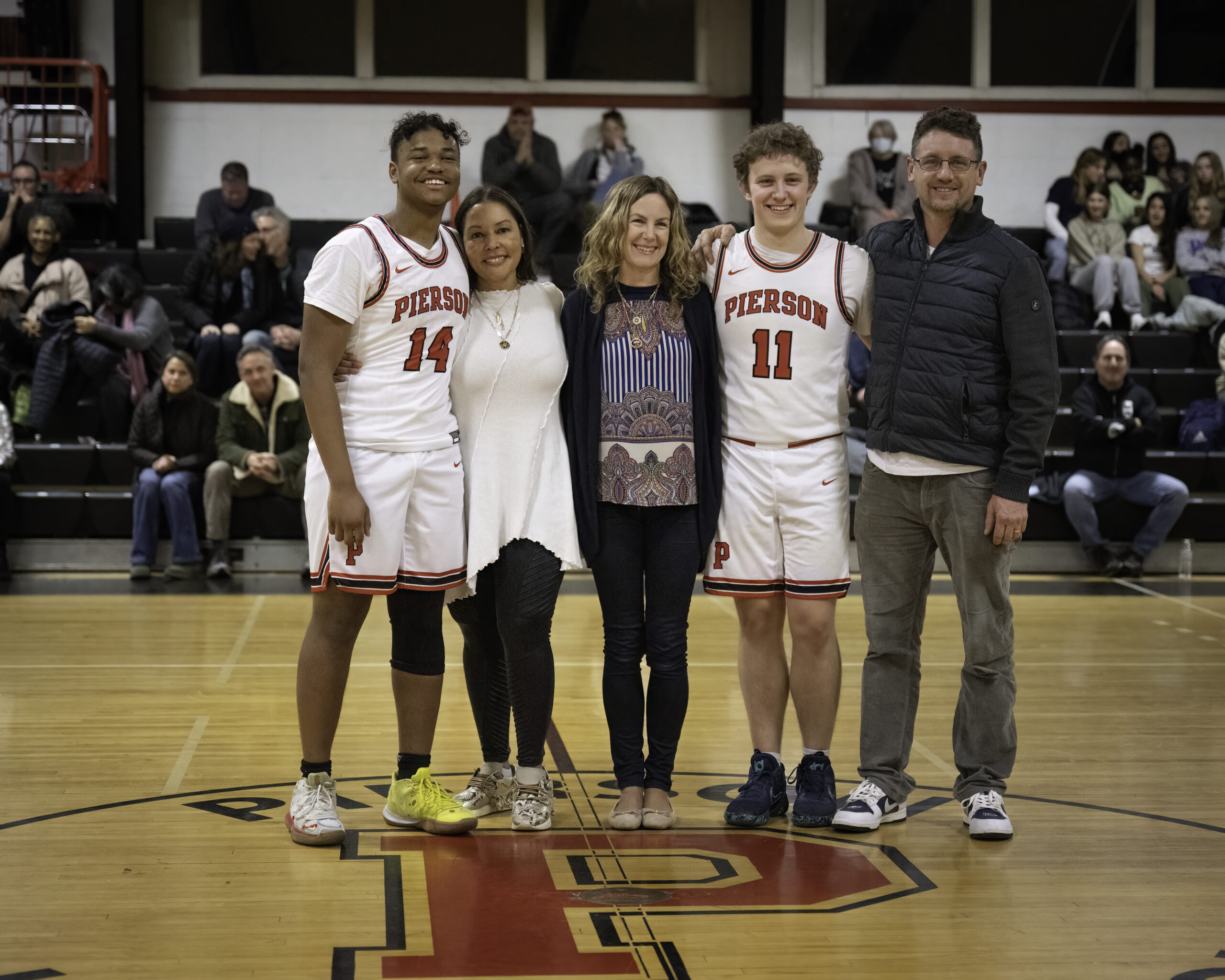 Fritz Desir, far left, with his mother Lucinda Martinez, and Logan Hartstein with his parents Heather Hartstein and Brendan O'Reilly. Both seniors were both honored prior to last week's game against Port Jeff.   MARIANNE BARNETT