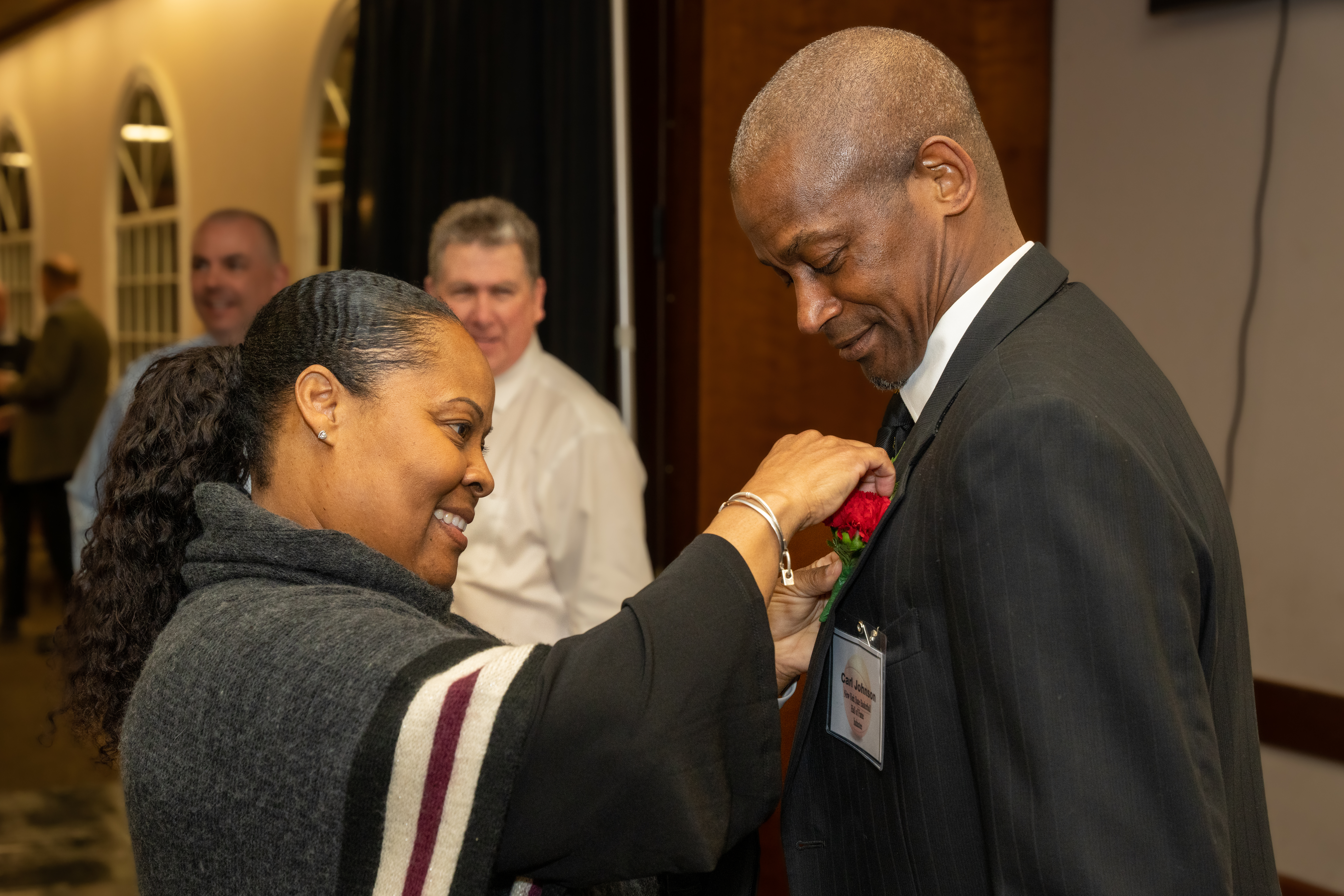 Aleta Parker puts a boutonniere on the lapel of her cousin Carl Johnson who was inducted into the New York State Basketball Hall of Fame on Sunday in Glens Falls.    RON ESPOSITO