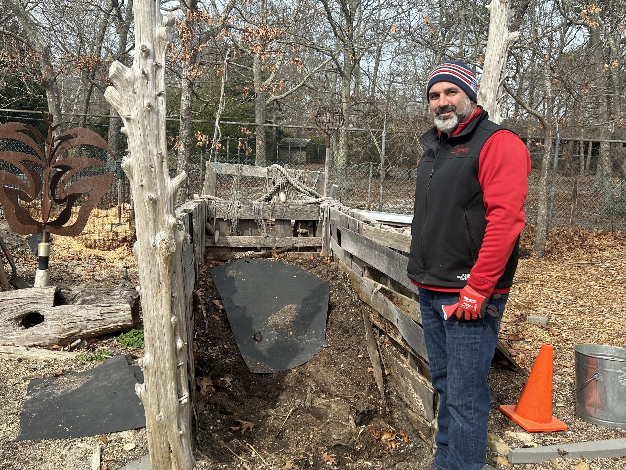 Tony Romano of the Ecological Cultural Initiative with one of three compost bins crafted of repurposed materials. ECI is running a community compost project at St. Joseph's Villas in Hampton Bays.     KITTY MERRILL