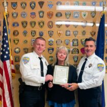 Reporter Kitty Merrill is given a Citizens Award by Quogue Village Police Lieutenant Daniel Hartman and Chief Christopher Isola.