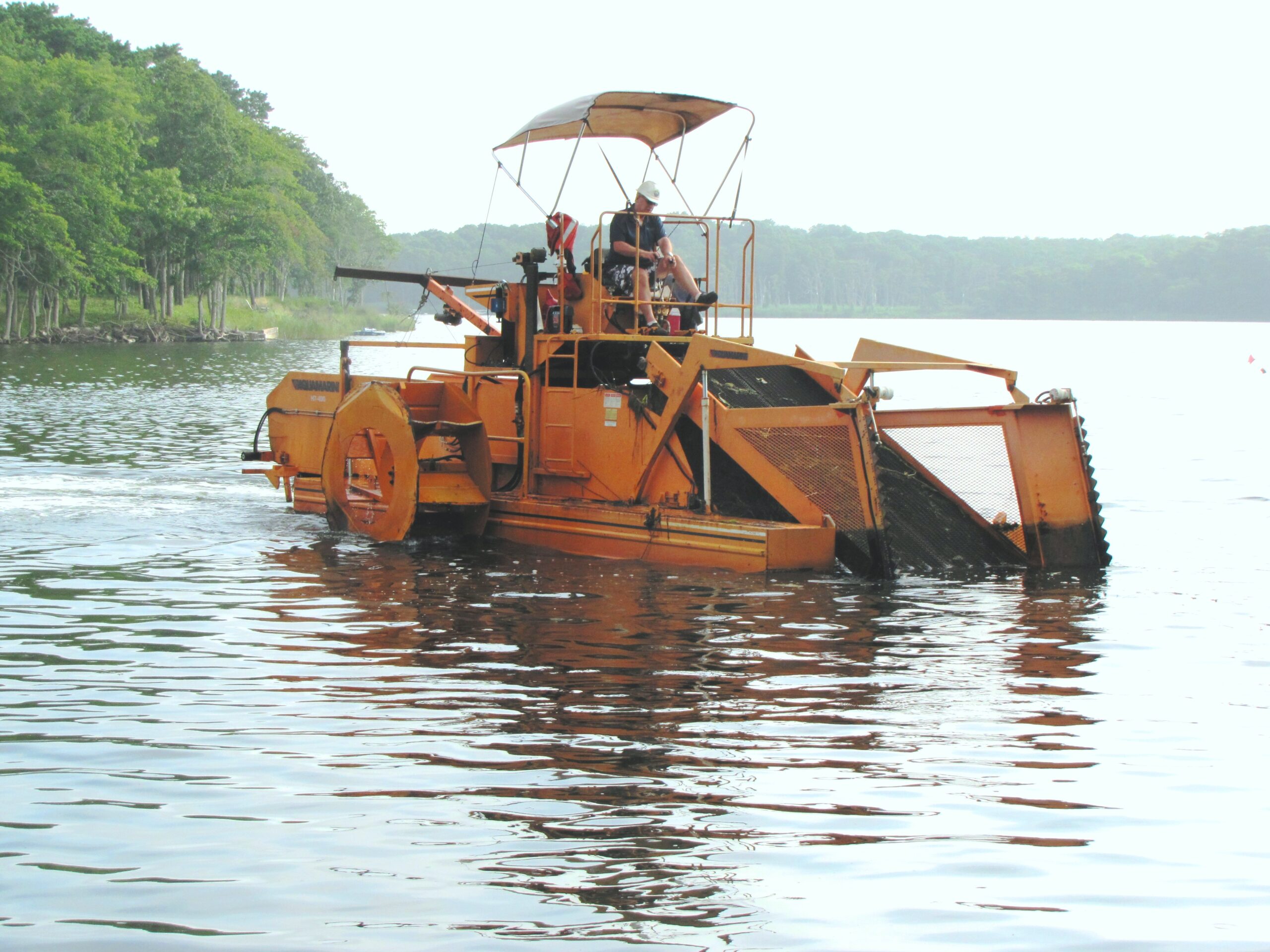 The Friends of Georgica Pond will deploy the aquatic harvester in the pond again this summer. Last year the floating tractor removed 72,000 pounds of nutrient-laden aquatic weeds from the pond, lowering the risk of toxic algae blooms.