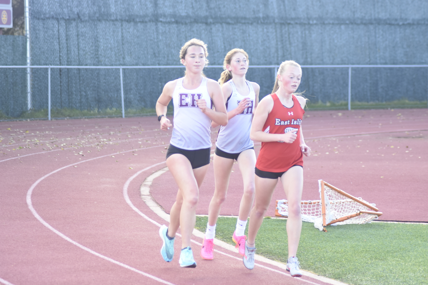 East Hampton's Dylan Cashin, left, and Pierson's Sara O'Brien on the tail of an East Islip runner in the 3,200-meter race of last week's dual meet.   DREW BUDD