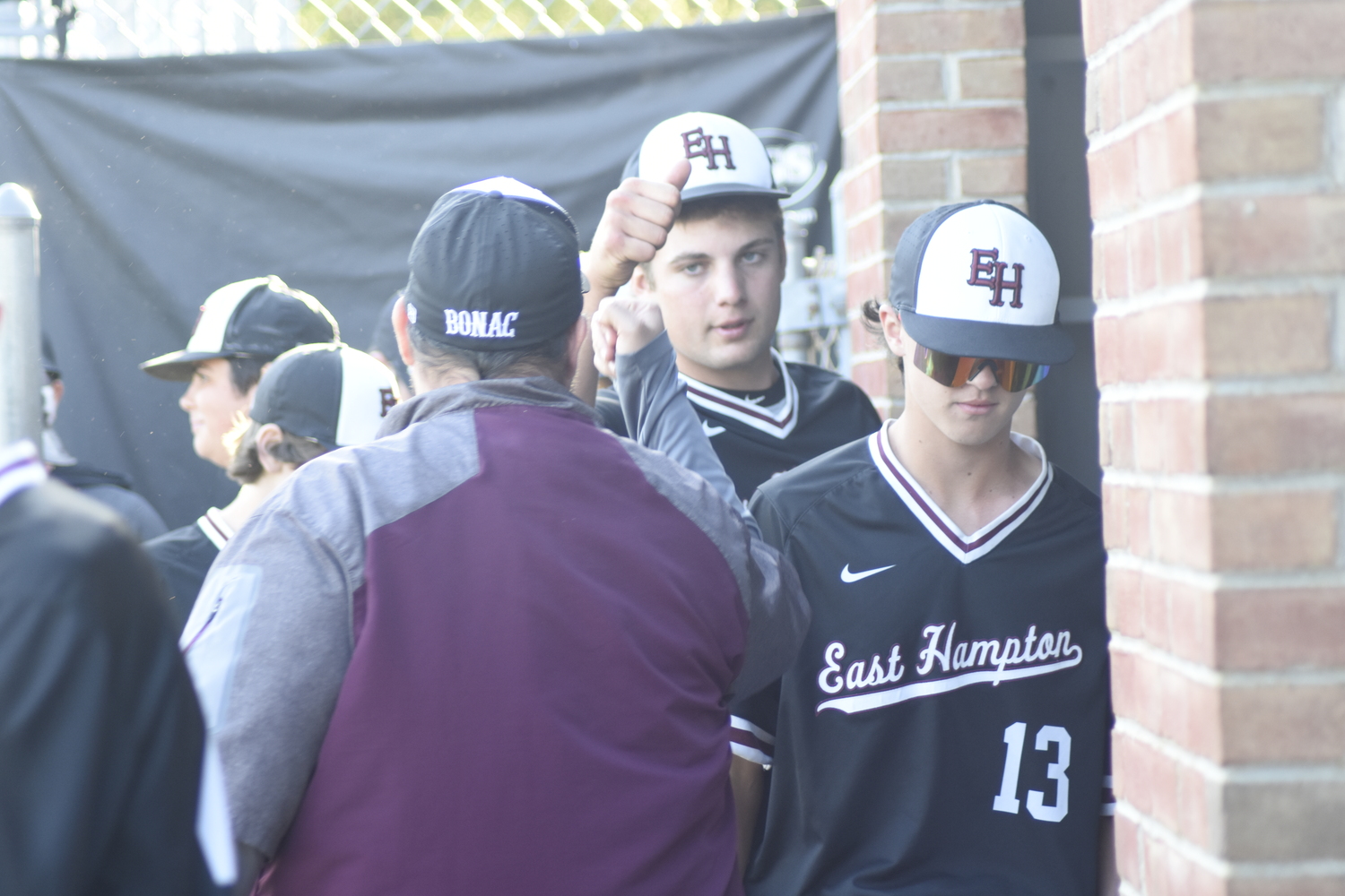 Jack Dickinson is congratulated by his coaches and teammates in the dugout.  DREW BUDD