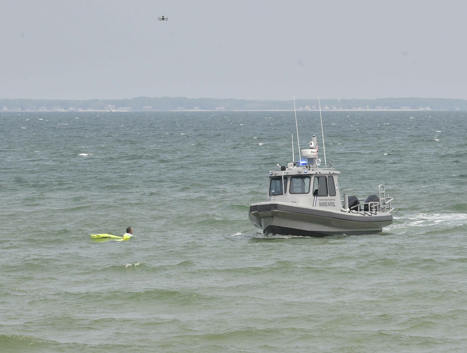 Under the watchful eye of a drone, the swimmer is picked up by Marine Patrol.   DANA SHAW